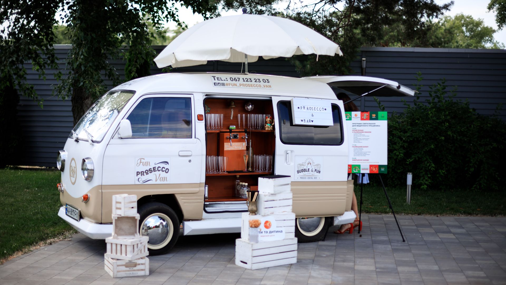 italiiyskyy-uikend-kliniky-maty-ta-dytyna-prosecco-na-vkhodi – Гості корпоративу отримують келихи просекко біля коктейль-бусика