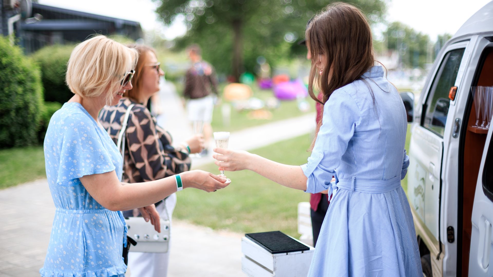 italiiyskyy-uikend-kliniky-maty-ta-dytyna-prosecco-na-vkhodi – Гості корпоративу отримують келихи просекко біля коктейль-бусика